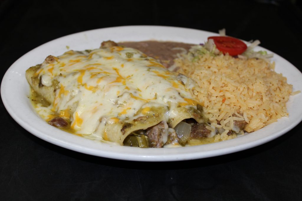 A plate of enchiladas, red, and beans.