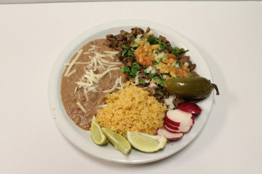 Carne asada, refriend beans, and rice on a plate.