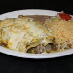 A plate of enchiladas, red, and beans.