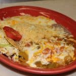 Dinner plate with a small taco, rice, and beans on a red plate.